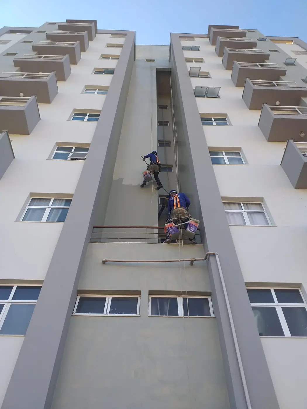 Técnico da BellaCor pintando fachada com acesso por corda NR-35